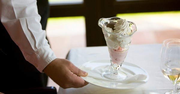 Waiter serving dessert